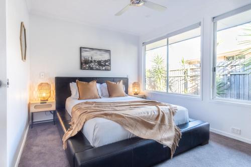 Un dormitorio con una cama grande y una ventana en Pet Friendly House Opposite Bokarina Beach en Kawana Waters