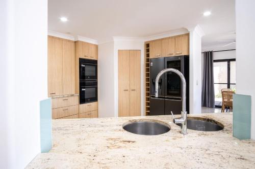 a kitchen with a sink and a counter top at Parrearra Paradise On The Water With Water Slide in Parrearra