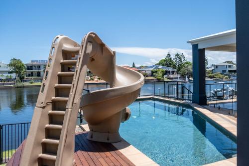 a slide next to a swimming pool with a sink at Parrearra Paradise On The Water With Water Slide in Parrearra