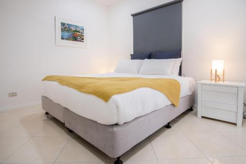 a bedroom with a large bed with a yellow blanket on it at Parrearra Paradise On The Water With Water Slide in Parrearra