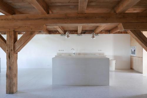 a kitchen with a white counter and wooden ceilings at Gorzelnia w Żarnowcu in Żarnowiec
