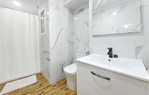 Baño blanco con lavabo y aseo en Gorgeous Home In Ador With Kitchen, en Ador