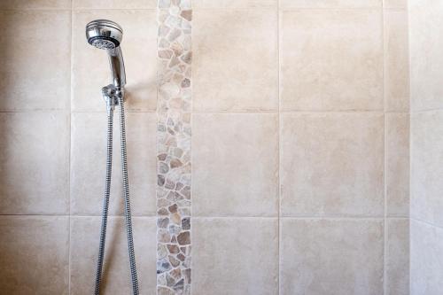 a shower with a shower head in a bathroom at Coastal Getaway Across From Dicky Beach in Caloundra