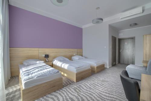 um quarto de hotel com duas camas e uma cadeira em Nova Stodola em Kłomnice