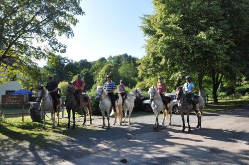 un groupe de personnes à cheval dans une rue dans l'établissement Les Chalets Du Moulin Du Châtain 1, à Payzac