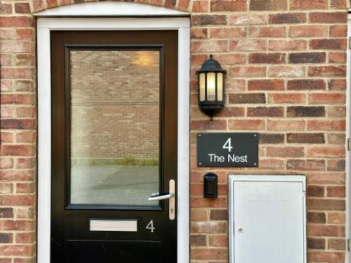 a door to a brick building with a sign on it at 4 The Nest Central Ripon in Ripon