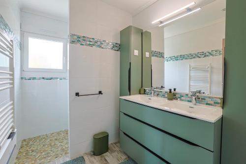 La salle de bains est pourvue d'un lavabo et d'un miroir. dans l'établissement Le Saint-Roch #Jardin #Paisible, à Cognac