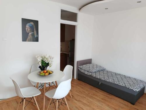 a bedroom with a bed and a table and chairs at Apartament fabryczny Comfort in Pisz