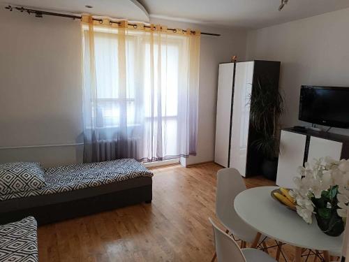 uma pequena sala de estar com uma mesa e um sofá em Apartament fabryczny Comfort em Pisz