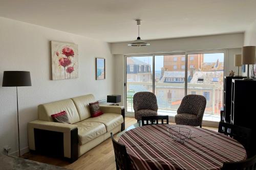 un salon avec un canapé et deux chaises dans l'établissement Agréable Appartement Balcon Parking, à Les Sables-dʼOlonne