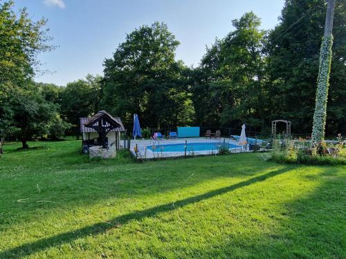 un gran patio con piscina y árboles en La Forestine, en Bergerac
