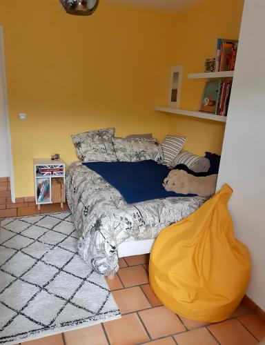 a bedroom with a bed and a yellow wall at Villa avec piscine à Fuveau in Fuveau