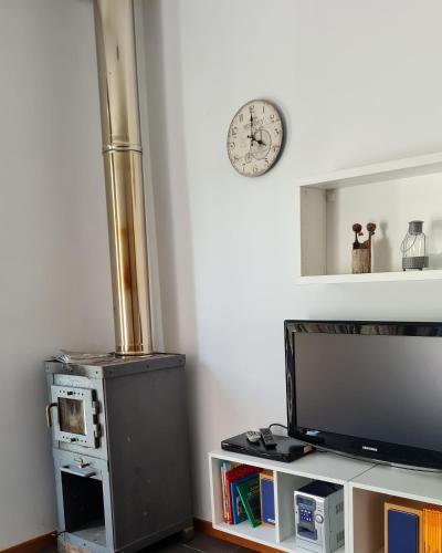 a living room with a television and a clock on the wall at Quinta do Paúl de Baixo in Guimarães