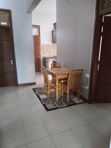 a kitchen with a wooden table and chairs at Modern 2 BR home w/ 3 ACs, 2 TVs near the beach in Dar es Salaam