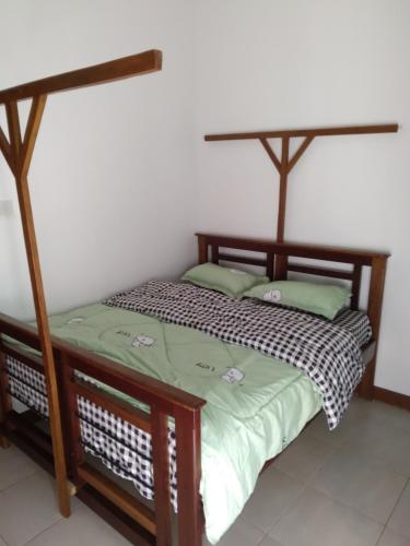 a bedroom with a bed with a wooden frame at Modern 2 BR home w/ 3 ACs, 2 TVs near the beach in Dar es Salaam