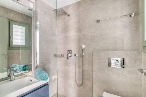 a bathroom with a shower and a tub and a sink at Villa Xifara - Seafront in Santa Maria