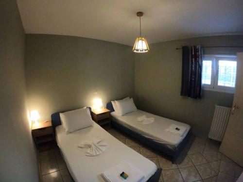 um quarto com duas camas num quarto com uma janela em Mavretas Apartments 4 em Argasi