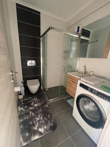 een badkamer met een wasmachine en een wastafel bij Elit Yaşam Site 1-Bedroom flat with pool in Fethiye