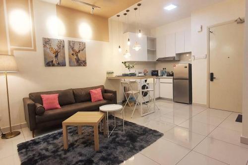 a living room with a couch and a kitchen at Arte Mont Kiara Studio Apartment Hartamas in Kuala Lumpur