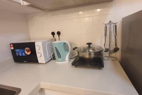 a kitchen counter with a stove and a toaster at Arte Mont Kiara Studio Apartment Hartamas in Kuala Lumpur