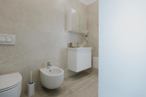 a white bathroom with a toilet and a sink at Hotel Kroi near castle entrance castle and town view in Krujë