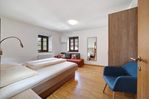 1 dormitorio con 1 cama y 1 silla azul en Appartement Wielander B West en Laces