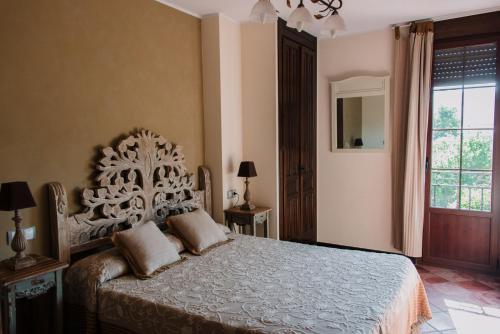 ein Schlafzimmer mit einem Bett und einem großen Fenster in der Unterkunft Entrada Río Lobos in Hontoria del Pinar
