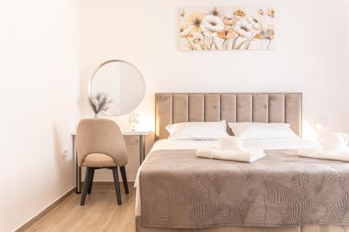 een slaapkamer met een bed, een stoel en een spiegel bij Villa Istra Relax Sapphire in Rebići