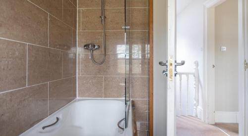 a bath tub with a shower in a bathroom at Mill Cottage in Sawrey