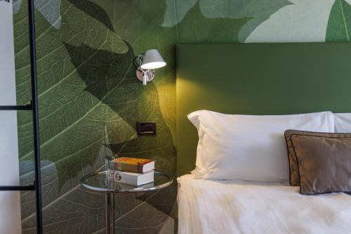 a bedroom with a bed with a green wall at Hotel Meridiana in Malcesine
