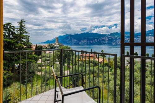 a bench on a balcony with a view of the water at Hotel Meridiana in Malcesine