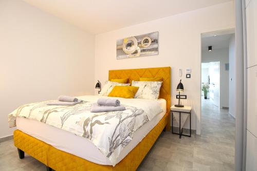 een slaapkamer met een groot bed met een geel hoofdeinde bij House Sanja 2278 in Pula