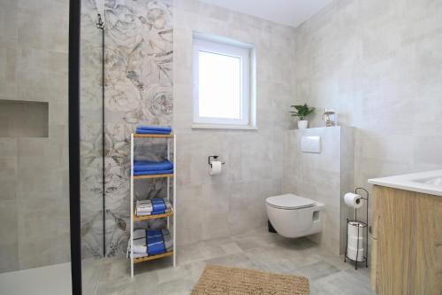 een badkamer met een douche, een toilet en een wastafel bij House Sanja 2278 in Pula