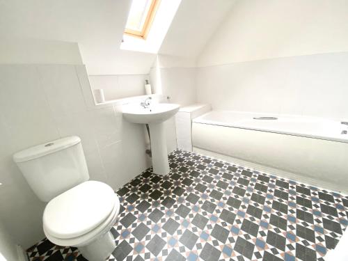 a bathroom with a toilet and a sink and a tub at Lochindaal - Beautiful, Spacious 4 Bedroom House in Kintyre in Whitehouse