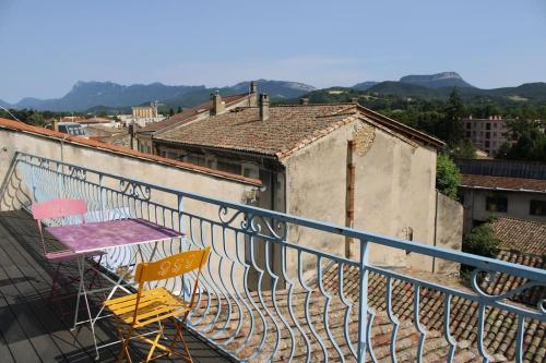 un balcón con 2 sillas y una mesa en un edificio en Chez Olivier, en Crest
