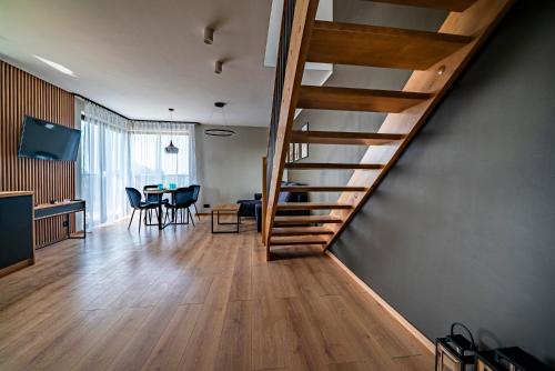 a staircase in a living room with a dining room at Apartamenty i Pokoje Złote Piaski in Jastrzębia Góra
