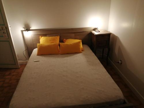 1 cama con 2 almohadas amarillas en una habitación en Maison Toulon ouest en Toulon