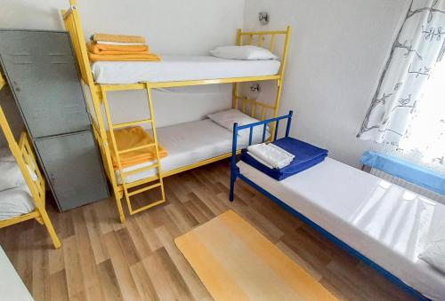 a room with three bunk beds and a wooden floor at Plitvice RH Hostel Rooms in Jezerce