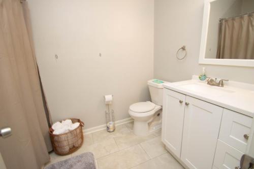 Baño blanco con aseo y lavamanos en Home Sweet Home in Camp Robinson, en North Little Rock