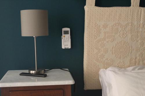 une lampe sur une table de nuit à côté d'un lit dans l'établissement Suite al castello, à Sassari