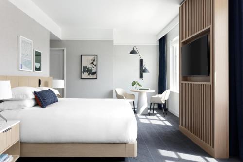 a bedroom with a bed and a tv and a table at Kimpton - The Forum Hotel by IHG in Charlottesville