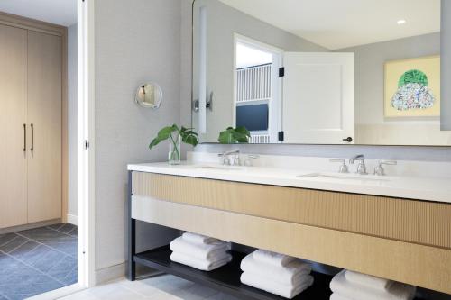 a bathroom with a sink and a mirror at Kimpton - The Forum Hotel by IHG in Charlottesville