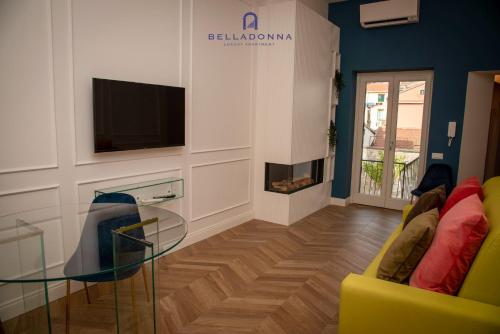 a living room with a yellow couch and a glass table at Belladonna Luxury Apartment in Cava deʼ Tirreni