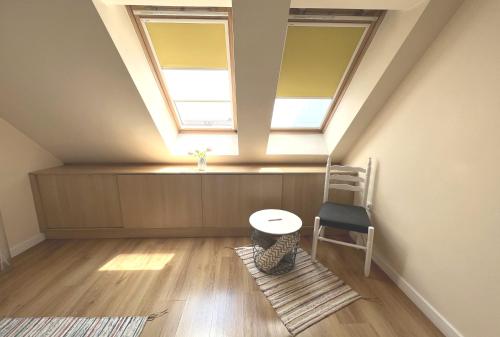 a room with a table and a chair and two windows at Unique Luxurious Jacuzzi PENTHOUSE DUPLEX in City Center! 2 BATHS! FREE PARKING! in Sofia