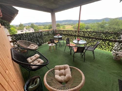 eine Terrasse mit Stühlen und Tischen auf dem Balkon in der Unterkunft CASA ARIAN in Haţeg