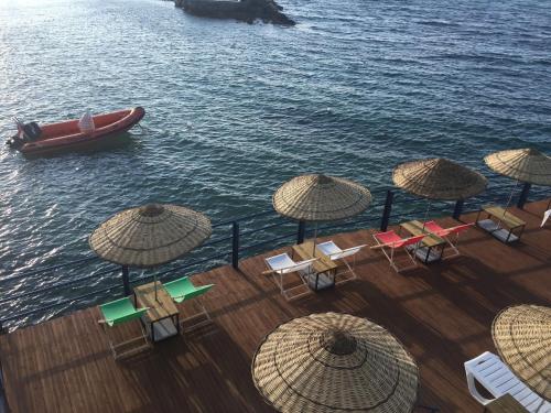 a boat in the water with chairs and umbrellas at Manolya Hotel in Kérynia
