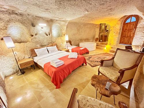 ein Schlafzimmer mit einem Bett in einem Steinzimmer in der Unterkunft Asma Altı Cave Suit's in Nar