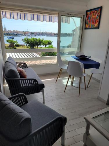 un salon avec un canapé, des chaises et une table dans l'établissement La plagette d'emy, au Cap d'Agde