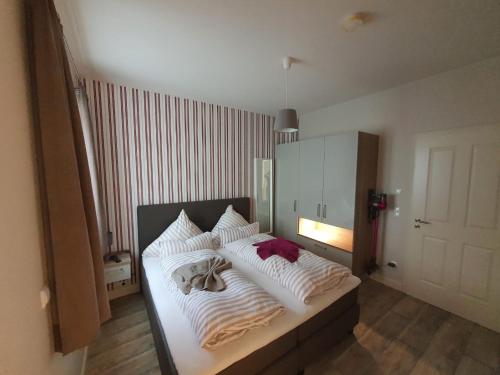 una camera da letto con un letto con coperte e cuscini bianchi di Alte Schulstraße Altstadtdomizil Wohnung Helin Whg 3 a Borkum
