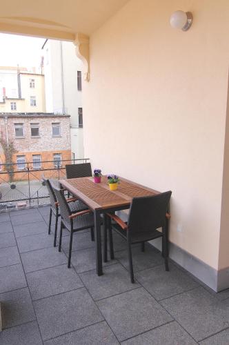 a wooden table and chairs on a patio at Pension Alba in Görlitz